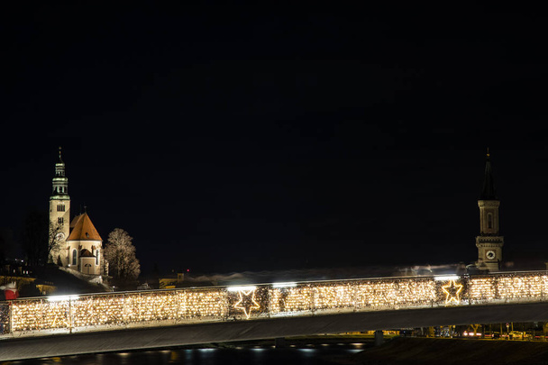М'який фокус Старе місто Європи Довгий експозиційний краєвид вночі церква вежі і міст з садом освітлення освітлення і нечіткі люди руху в час ходьби. - Фото, зображення