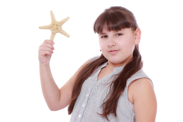Little girl holding star fish on white background - Foto, imagen