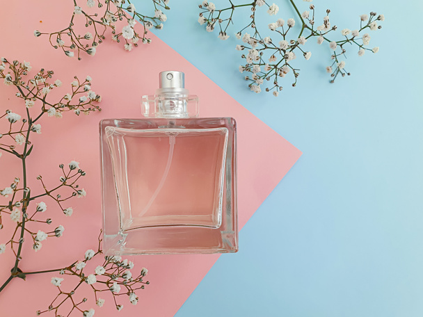 Renkli arka planda bir şişe parfümü çiçeği. - Fotoğraf, Görsel