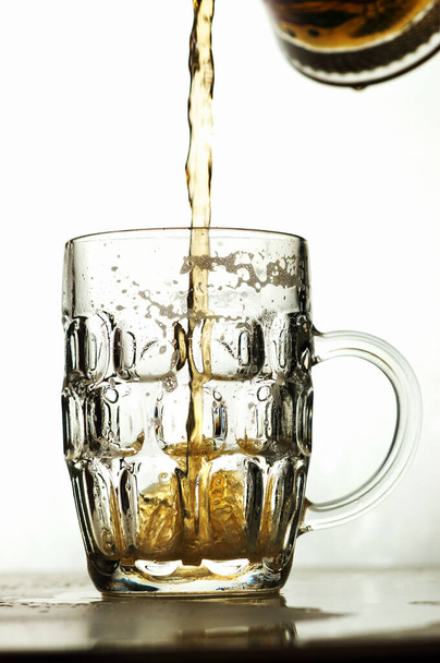 foamy beer in a transparent glass and a pile of potato chips on a white background - 写真・画像