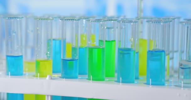Bir laboratuarda, pipetli bir bilim adamı test tüplerindeki DNA ve molekülleri ayırmak için renkli bir sıvıyı analiz eder. Konsept: araştırma, biyokimya, doğa, ilaç - Video, Çekim