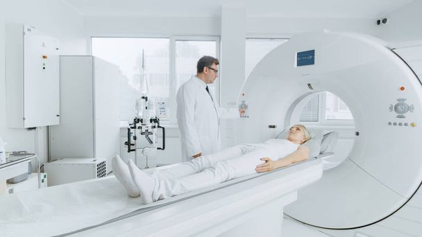 In Medical Laboratory Radiologist Controls MRI or CT or PET Scan with Female Patient Undergoing Procedure. Professional Doctor Conducts Emergency Checkup Procedure with Advanced Medical Technologies. - Foto, Bild