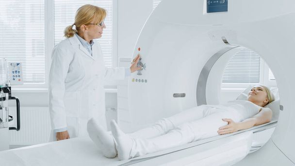 In Medical Laboratory Radiologist Controls MRI or CT or PET Scan with Female Patient Undergoing Procedure. High-Tech Modern Medical Equipment. Friendly Doctor Chats with Patient. - Fotoğraf, Görsel