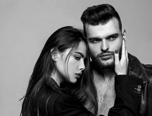 Man brutal well groomed macho and attractive feminine girl long hair cuddling. Girlfriend passionate red lips and man leather jacket. Passionate hug. Couple passionate people in love. Passion fashion - Photo, image