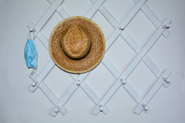 Pasillo blanco guardarropa con un respirador colgado y un sombrero a la izquierda - Foto, imagen