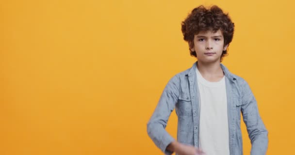 Portret van kleine jongen met gevouwen armen die minachting of ergernis uitdrukken, kijkend naar camera met veroordeling - Video
