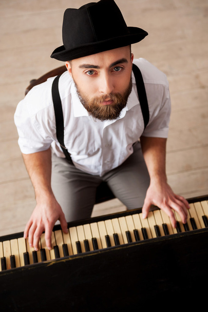 κάτοψη γενειοφόρος ανδρών, παίζει πιάνο και αναζητούν σε κάμερα - Φωτογραφία, εικόνα