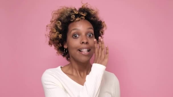 アフリカ系アメリカ人の女性が手で口を覆い秘密を話す. - 映像、動画