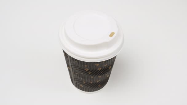 two female hands hold a paper cup with cappuccino on a white table, opens a plastic lid - Footage, Video