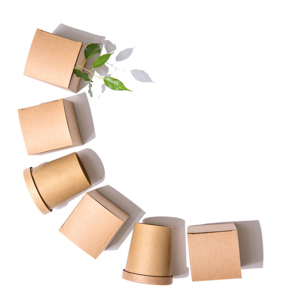 Delivery concept, takeaway, packaging, save the earth. Cardboard boxes for food, drinks and objects. Square and round. Green leaves. White background. Isolate Top view. - Photo, Image