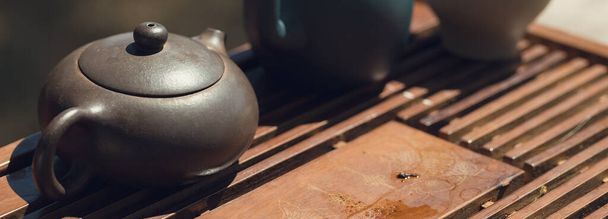 Chinesische Teezeremonie. Keramische Teekanne aus Ton und Schalen auf einem hölzernen Hintergrund. - Foto, Bild