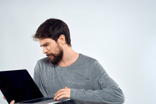 Un hombre en un suéter gris con un portátil manos estilo de vida tecnología comunicación internet trabajo - Foto, imagen