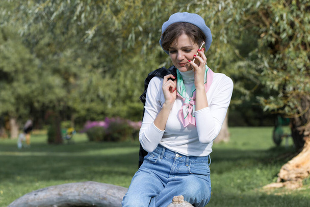 公園の若い女性は携帯電話で話す。かわいいです女の子の肖像画でフランス語スタイル. - 写真・画像