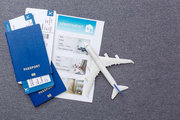 Flight tickets with passports, model of airplane and map on gray background. - Valokuva, kuva