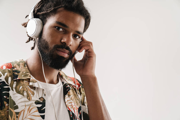 close-up portret van een jonge zwarte man luisteren naar muziek met hoofdtelefoon - Foto, afbeelding
