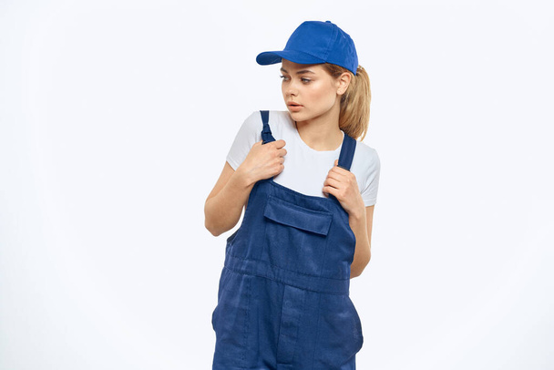 İş üniformalı bir kadın. Mavi şapkalı, kurye teslimat servisi. - Fotoğraf, Görsel