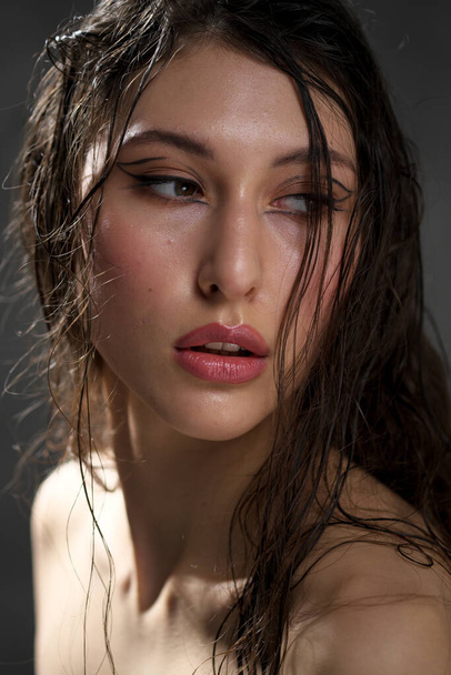 The face of a beautiful young girl with wet black hair close-up. Eastern appearance. Nude makeup, natural skin. - Fotoğraf, Görsel