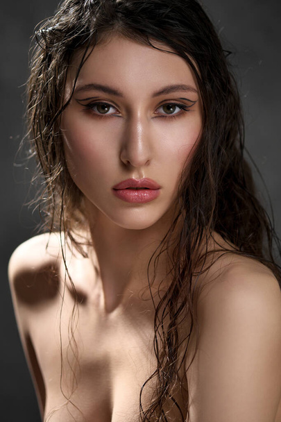 The face of a beautiful young girl with wet black hair close-up. Eastern appearance. Nude makeup, natural skin. - Valokuva, kuva