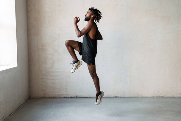 Image of handsome african american sportsman jumping while working out indoors - Zdjęcie, obraz