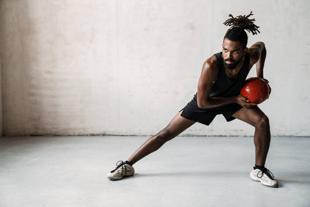 Image of athletic african american sportsman working out with medicine ball indoors - Fotografie, Obrázek
