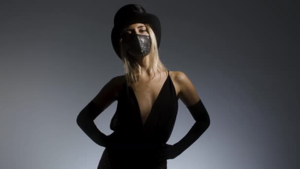 Νεαρή γυναίκα με αστραφτερή μάσκα προσώπου και ψηλό καπέλο - Πλάνα, βίντεο