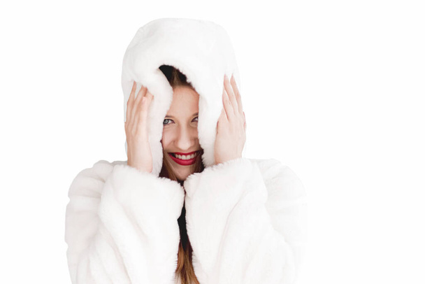Young woman in fluffy fur coat with hood wrap, warm winter clothing for fashion and Christmas holidays - Fotoğraf, Görsel