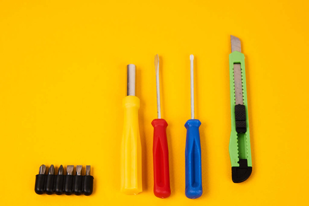 psací nůž šroubováky a stavební nářadí na žlutém podkladě zařízení pro opravárenský průmysl - Fotografie, Obrázek