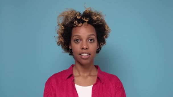 Hübsche junge Afroamerikanerin macht Schweigegegeste, drückt Zeigefinger an Lippen. - Filmmaterial, Video