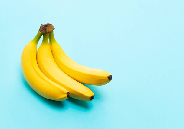 Bananas on a blue background with a copy space - Фото, изображение