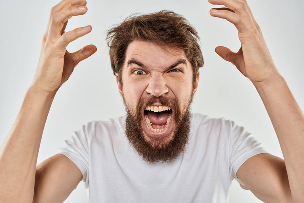 hombre emocional con una barba gesto con sus manos primer plano estudio agresión - Foto, imagen
