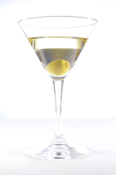 Glass with martini and olive on a white background - Фото, изображение