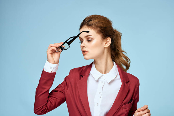 Επιχειρηματίας γυναίκα κόκκινο σακάκι γυαλιά επαγγελματική κάρτα εκτελεστικό μπλε φόντο - Φωτογραφία, εικόνα