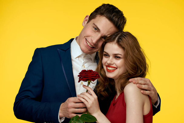 Ζευγάρι στην αγάπη άνθρωπος και γυναίκα με κόκκινο τριαντάφυλλο κλασικό κοστούμι κόκκινο φόρεμα μοντέλο - Φωτογραφία, εικόνα