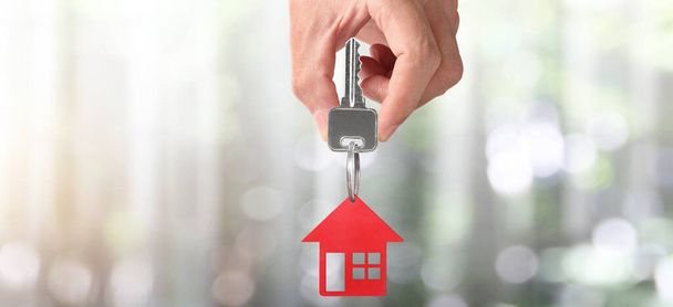 Agente immobiliare consegna le chiavi di una casa in mano, e monete - Foto, immagini