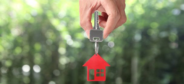 Agente inmobiliario entregando las llaves de una casa en la mano, y monedas - Foto, Imagen