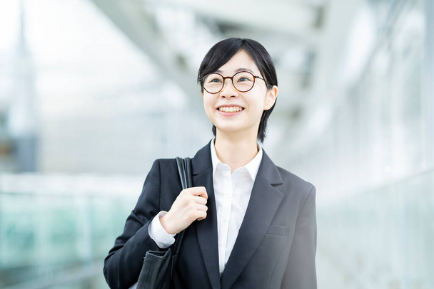 Азійська молода жінка в костюмі і окуляри з посмішкою. - Фото, зображення