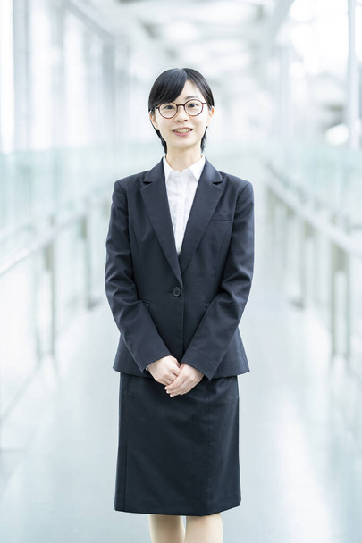 Asiatische junge Frau im Anzug und Brille mit Lächeln - Foto, Bild