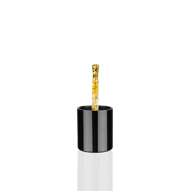 Χρυσό γυαλιστερό βερνίκι νυχιών σε μαύρο πλαστικό πινέλο σε λευκό φόντο απομονωμένο από κοντά, ανοιχτό χρυσό βερνίκι sequin, λαμπερό λαμπερό κίτρινο βερνίκι, αφρώδες σμάλτο, gel shimmer, καλλυντικό αξεσουάρ - Φωτογραφία, εικόνα