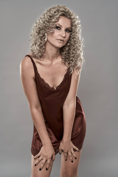 Closeup of a glamour model with blonde curly hair in lingerie - Fotó, kép