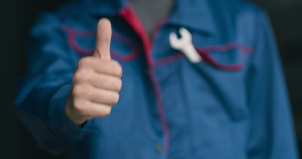 Close up of professional mechanic in uniform gesturing thumb up to camera, approval concept - Footage, Video