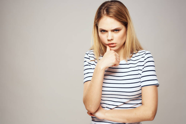 Emotional blonde woman in striped t-shirt lifestyle facial expression close-up - Fotó, kép
