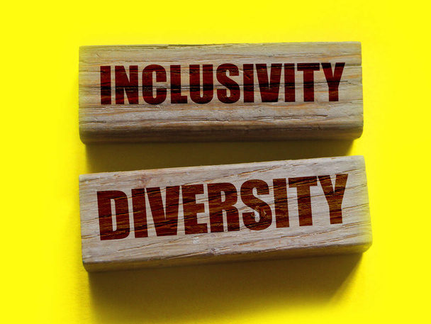 Inclusivity sokszínűség szavak fa blokk a sárga háttér. Társadalmi tolerancia fogalma - Fotó, kép