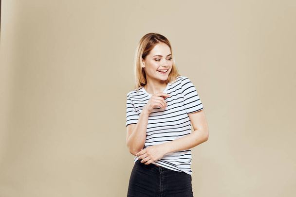 Cheerful woman striped t-shirt studio beige background lifestyle emotions - Fotografie, Obrázek