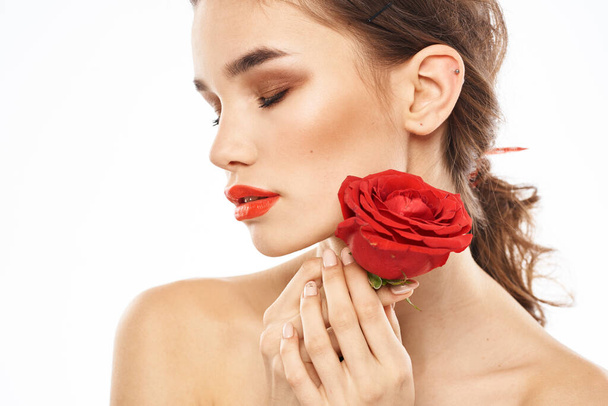 charming brunette girl with makeup on her face and a red rose in her hand - Fotoğraf, Görsel