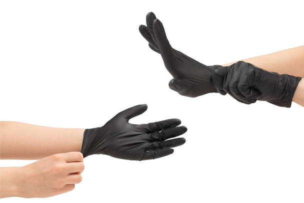 Μια γυναίκα φοράει μαύρα λαστιχένια γάντια. Απομονωμένα σε λευκό. - Φωτογραφία, εικόνα