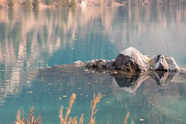 Abstraktní krajina podzimních barev - horské balvany v malebném jezeře. Koncept místního cestování. Almaty, Kazachstán. - Fotografie, Obrázek