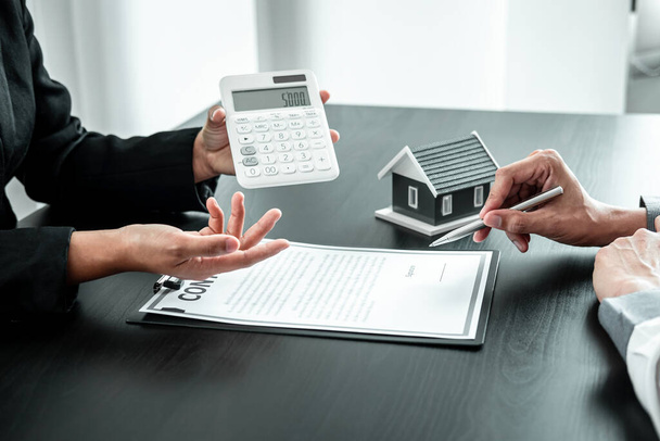 Агент з продажу нерухомості представляє кредит для клієнтів, щоб вони вирішили підписати контракт на оренду страхового будинку з затвердженою формою власності.. - Фото, зображення