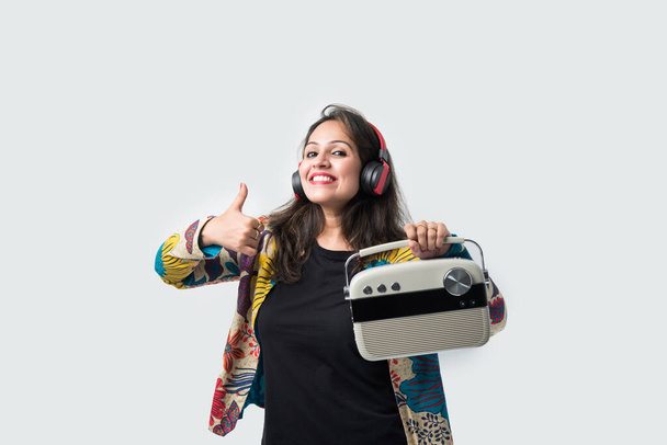 Indiai ázsiai lány vagy fiatal nő hallgat rádió fejhallgató, tánc ütemben, és szórakozás - Fotó, kép
