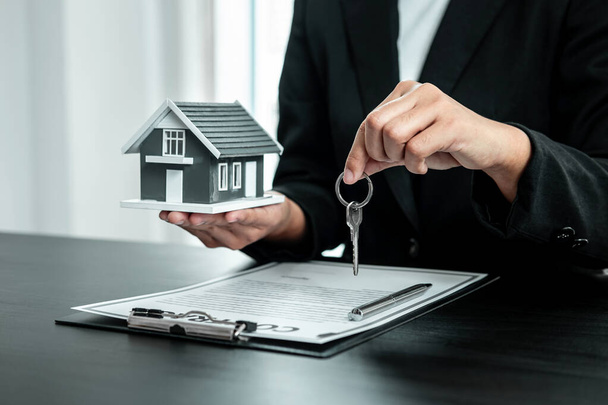 Eladó Ingatlan ügynök ad ház modell és kulcs az új ügyfél aláírása után megállapodást kötött jóváhagyott ingatlan űrlap, Lakásbiztosítás és ingatlan befektetési koncepció. - Fotó, kép