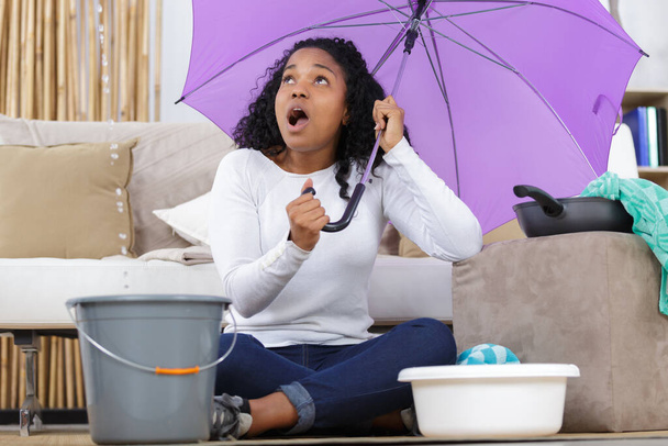 woman opening umbrella at home - Foto, immagini